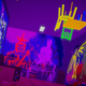 Neon chairs hang from the ceiling in a graffiti marked hallway.